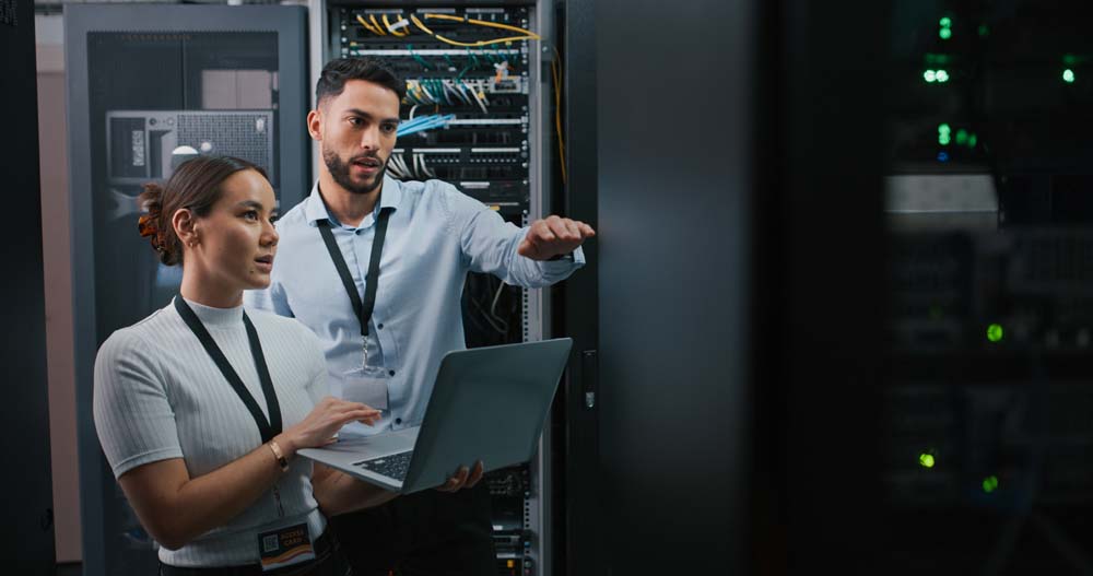 two colleagues working together in a server room