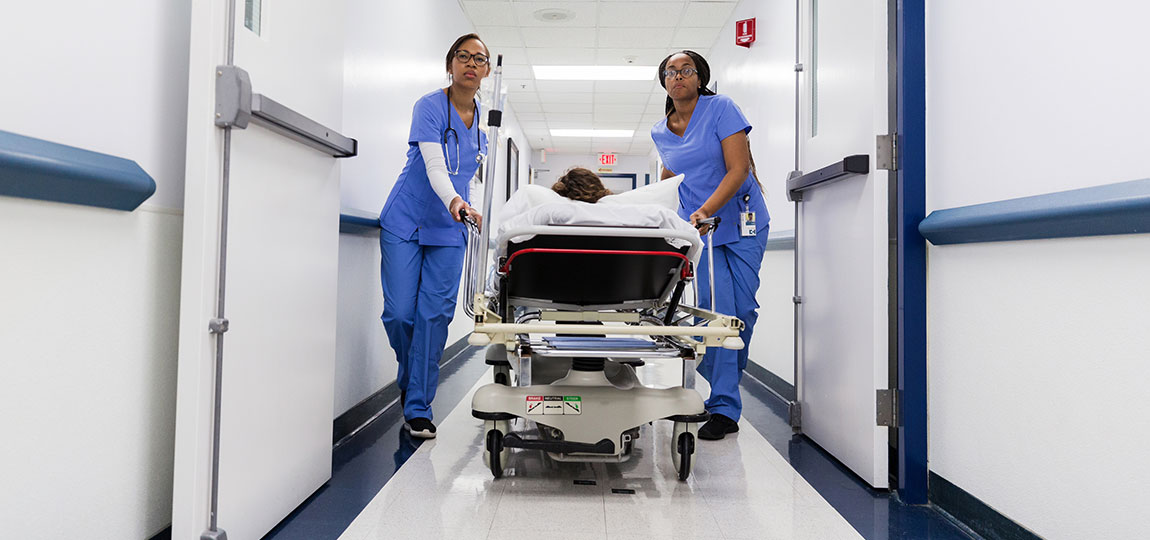 nurses moving a patient down the hall in a hospital